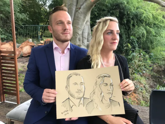 A man and woman hold a portrait drawing by Björn von Schlippe