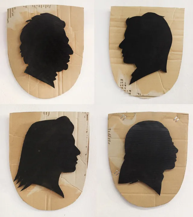 Four black silhouette profile portraits painted on cardboard by Björn von Schlippe