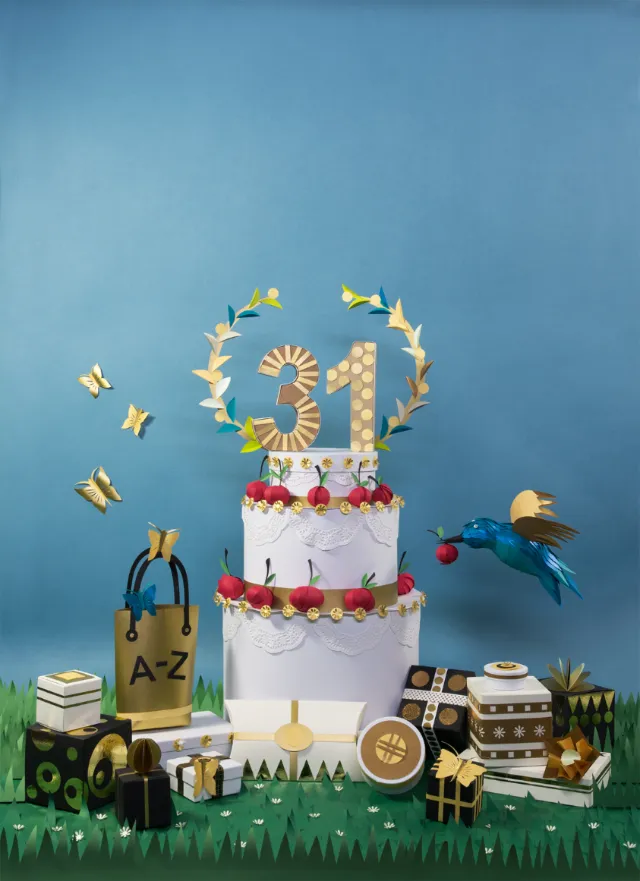 Three-tier birthday cake with gold 21 topper, gifts, and birds by Martha von Maydell