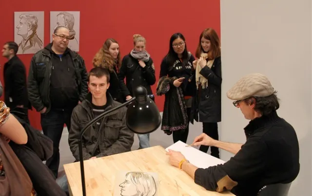 Artist sketching a portrait with spectators in an art gallery by Björn von Schlippe
