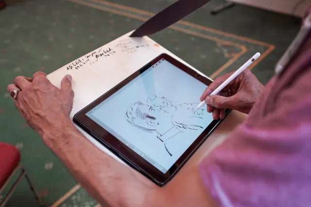Person drawing a digital portrait on tablet with stylus by Björn von Schlippe
