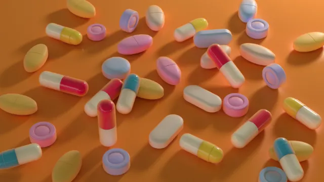 Colorful capsules and pills on orange background, by RIVE GAUCHE