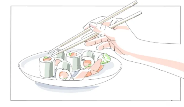 Hand using chopsticks to pick sushi from plate by Björn von Schlippe
