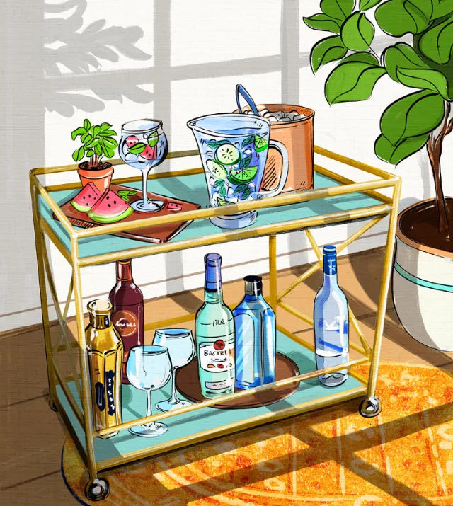 Bar trolley with various bottles, glasses, and a plant by a window by Amber Day