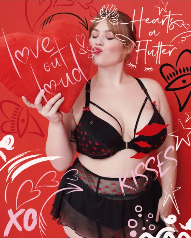 Woman in black lingerie holding heart balloon with drawn hearts by Nadia Flower