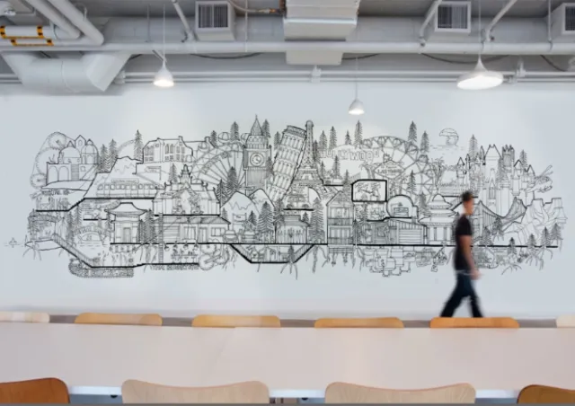 Cityscape mural in black and white on wall with person walking by, artist Ellie Compton