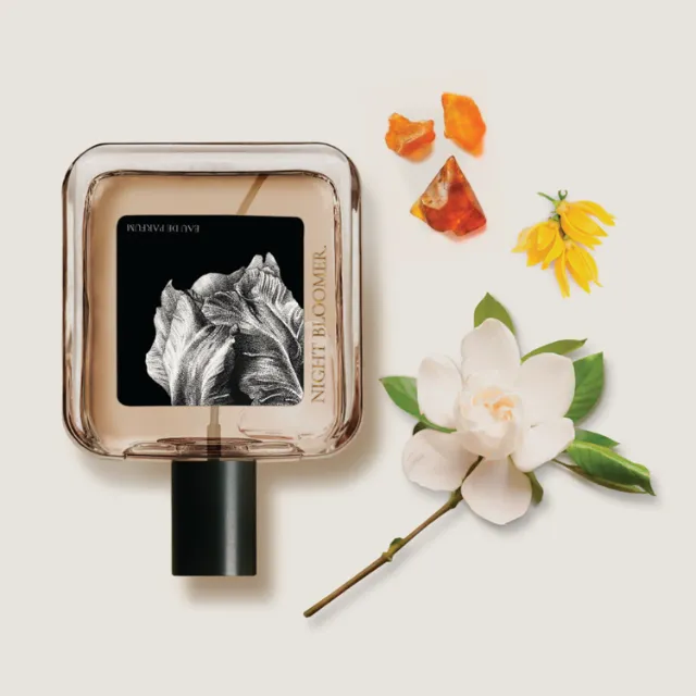 Perfume bottle labeled Night Bloom with white and yellow flowers by Reiko Lauper