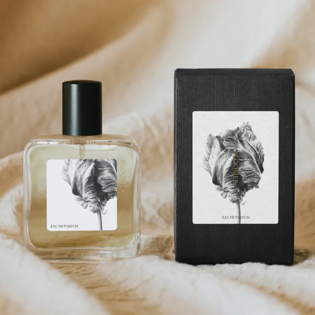 Perfume bottle and black box with black feather artwork by Reiko Lauper