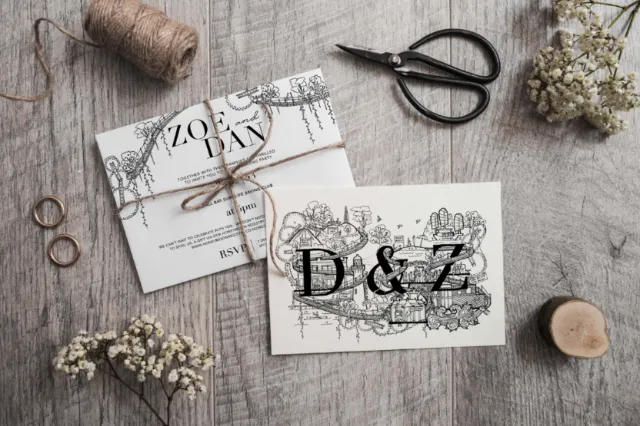 Wedding invitations with floral designs tied with string on wooden table
