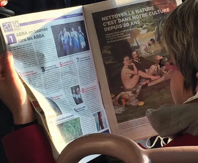 Person reading French magazine with ABBA and nature culture articles.