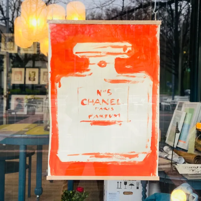Painting of Chanel No. 5 perfume bottle in red and white colors.