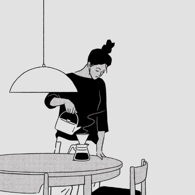 Person pouring coffee into a brewer on a round table