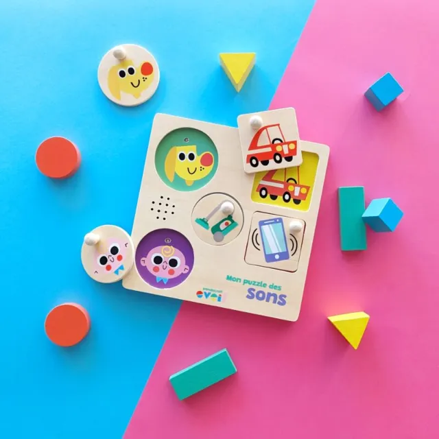 Children's sound puzzle with colorful pieces and vehicle images on blue and pink surface