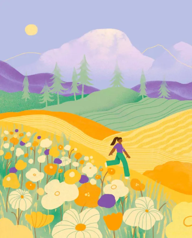 Person walking in vibrant flower fields with mountains and sunset sky