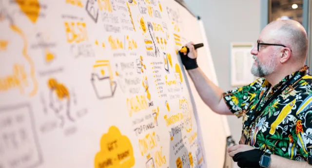 Man drawing diagrams on whiteboard by Tim Weiffenbach