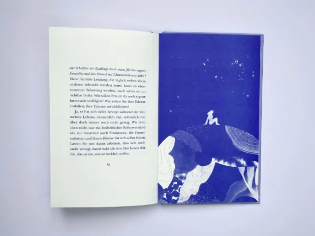 Open book with German text on left and blue artwork on right