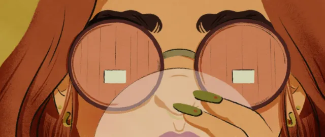 Close-up of person with round glasses holding green object near face.