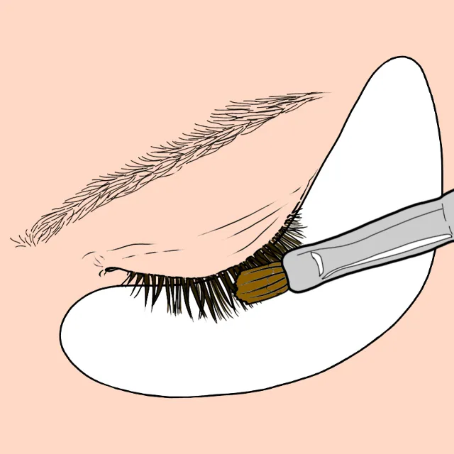 Makeup brush applying product to eyelashes with under-eye patch