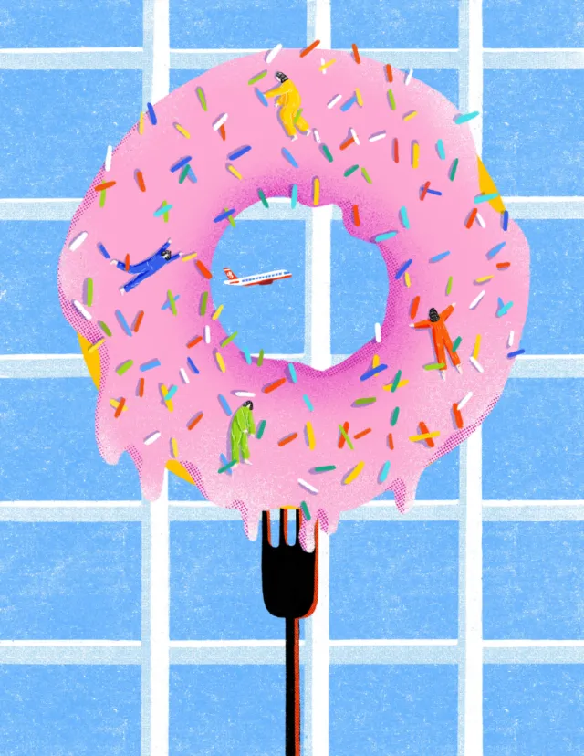 Pink frosted donut with colorful sprinkles and tiny people climbing on it