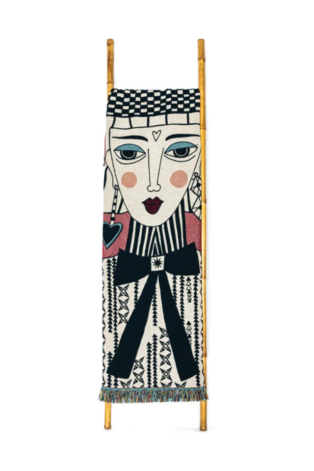 Textile wall hanging with stylized human face and geometric designs