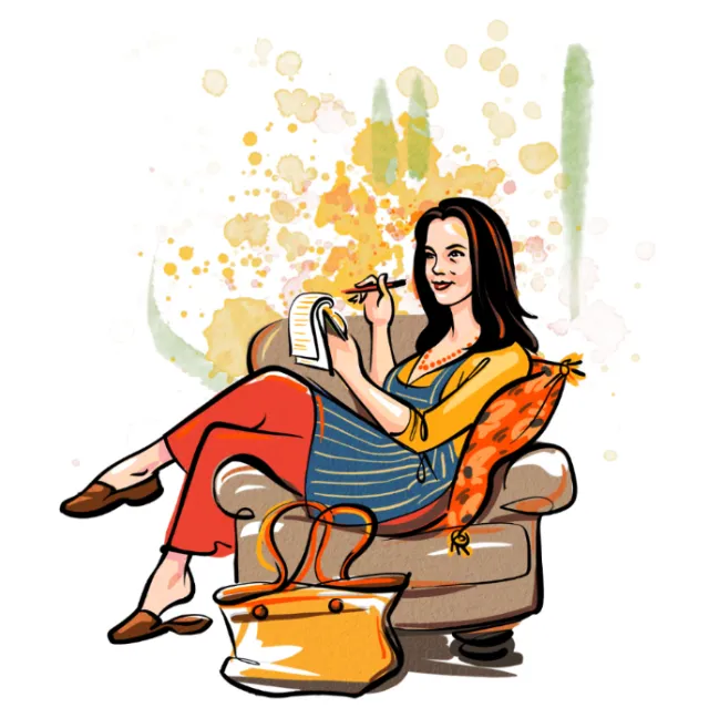 Woman writing in notebook while sitting on armchair with cushion