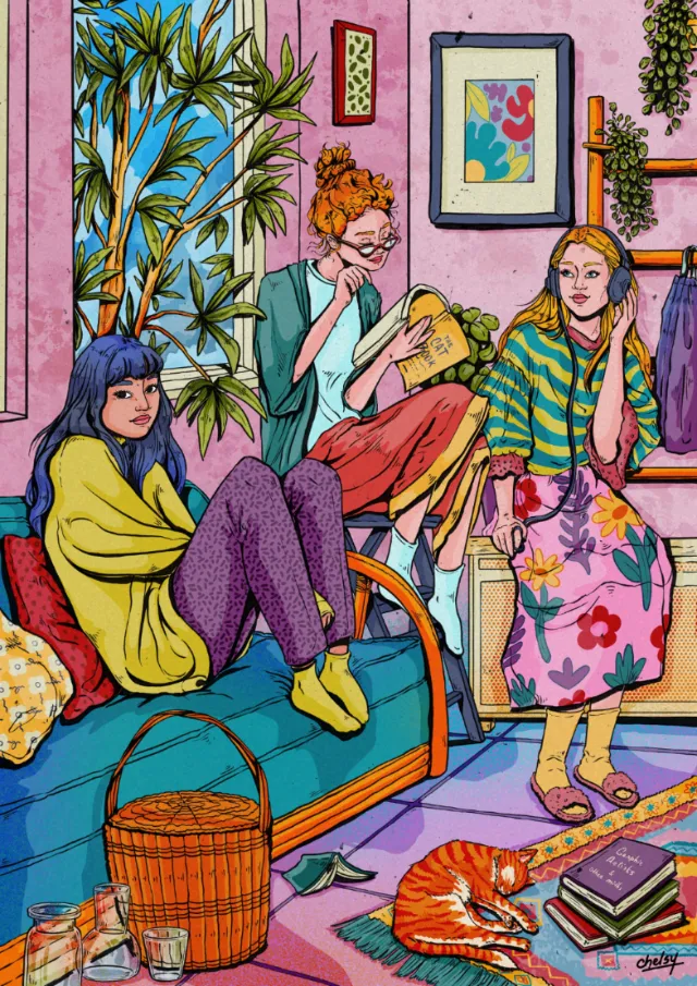 Three women sitting in colorful room with plants and cat