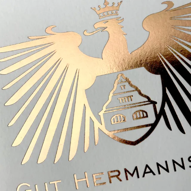 Gold foil embossed eagle emblem with crown and shield design