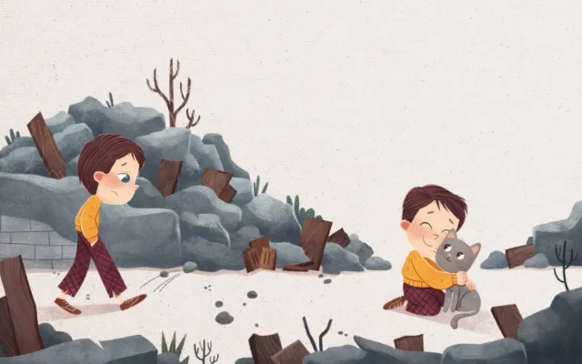 Boy playing with cat near rocks and wood debris