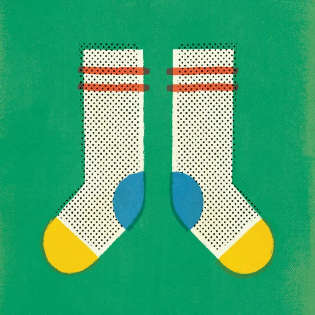 Pair of white socks with black dots, yellow toes, and red stripes
