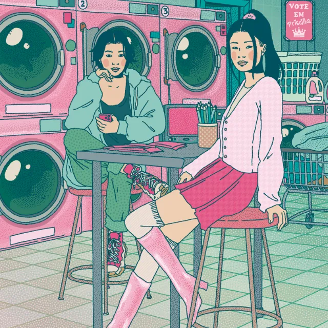 Two young women sitting in laundromat with pink and teal machines