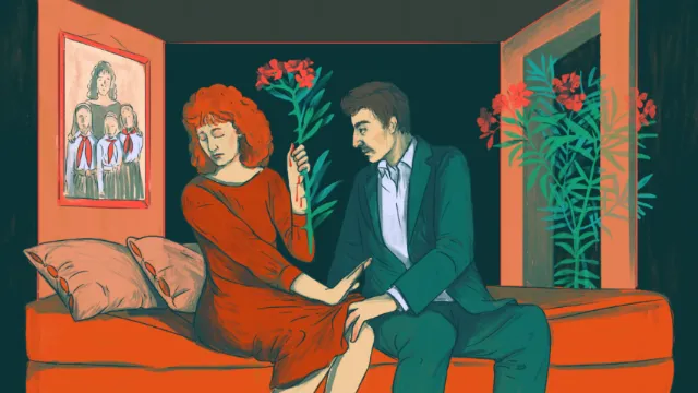 Couple sitting on a couch with the man giving flowers to the woman