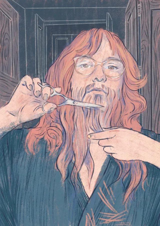 Person with long red hair cutting beard with scissors