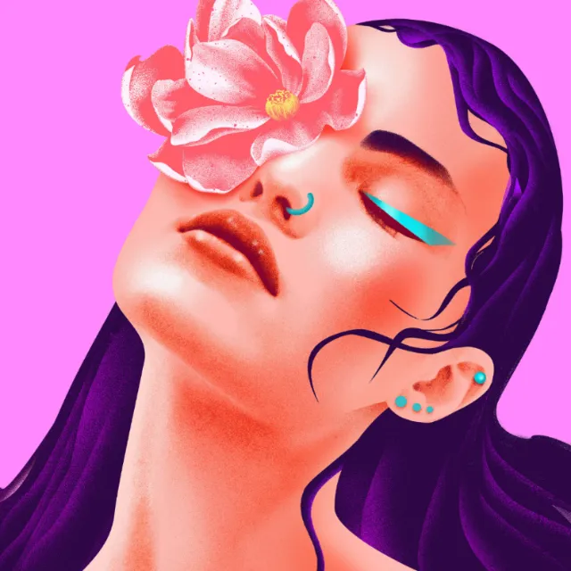Woman's face with pink flower covering eye and bright makeup on pink background