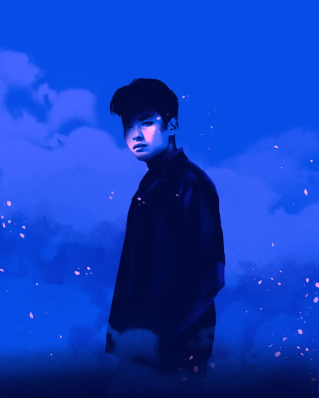 Young man standing with blue sky and clouds background