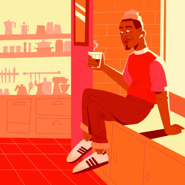 Man sitting on kitchen counter holding a cup of coffee
