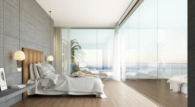 Modern bedroom with ocean view through large windows by Oliver Hasselluhn