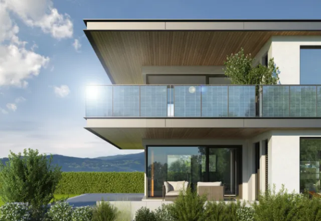 Modern house with balcony, glass railings, and garden outdoors