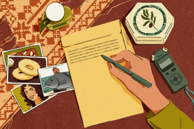 Hand writing letter next to photos, candle, and voice recorder.