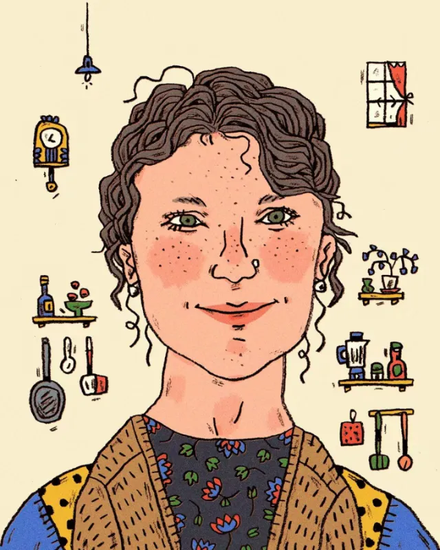Smiling woman with curly hair in a kitchen surrounded by utensils and plants