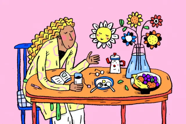 Woman having breakfast at table with flowers and fruit bowl