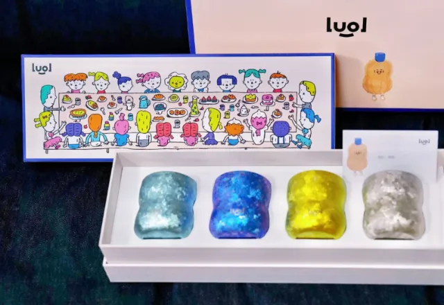 Four gummy bear-shaped candles in different colors in a white gift box