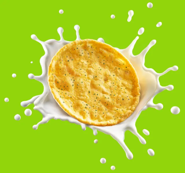 Protein crisp snack splashing into white liquid on green background