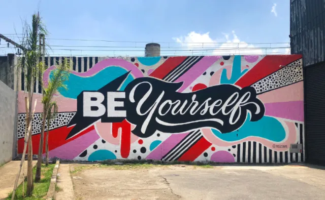 Colorful graffiti mural with text 'Be Yourself' by Mel Cerri