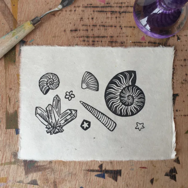 Black and white linocut print of fossils and minerals by Becca Thorne