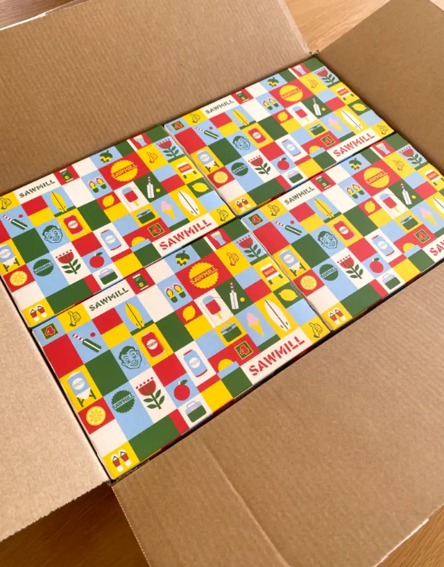 Colorful patterned cardboard boxes packed in a shipping box by Greg Straight