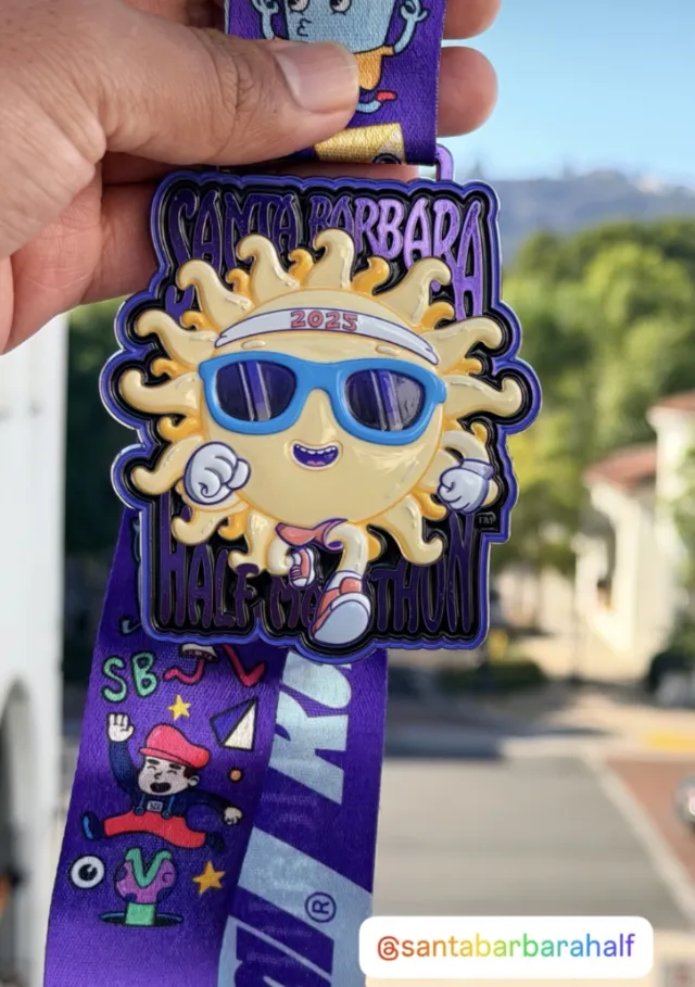 Santa Barbara Half Marathon medal featuring sun character with sunglasses by Daniel Sulzberg