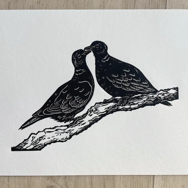 Black lino cut of two turtle doves on a branch by Emily Robertson