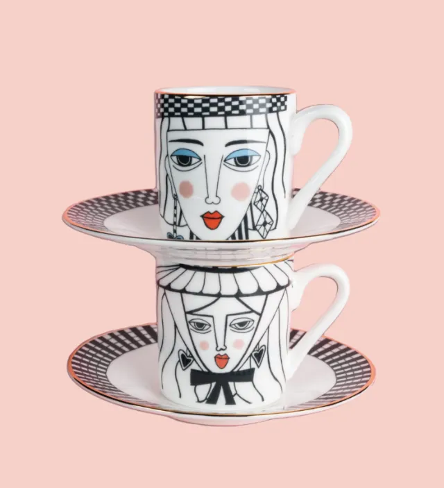 Two stacked illustrated teacups with faces on saucers by Hannah Davies