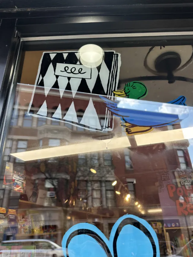 Indie Bookstore Day window mural featuring cartoon character by Ollie Wootton