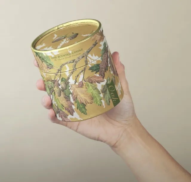Hand holding scented candle with botanical illustration by Marieke Nelissen